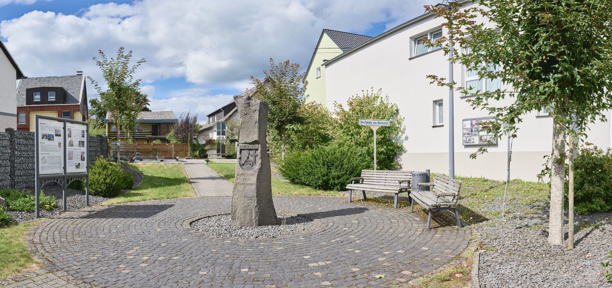 Dorfplatz mit Denkmal und Informationstafeln