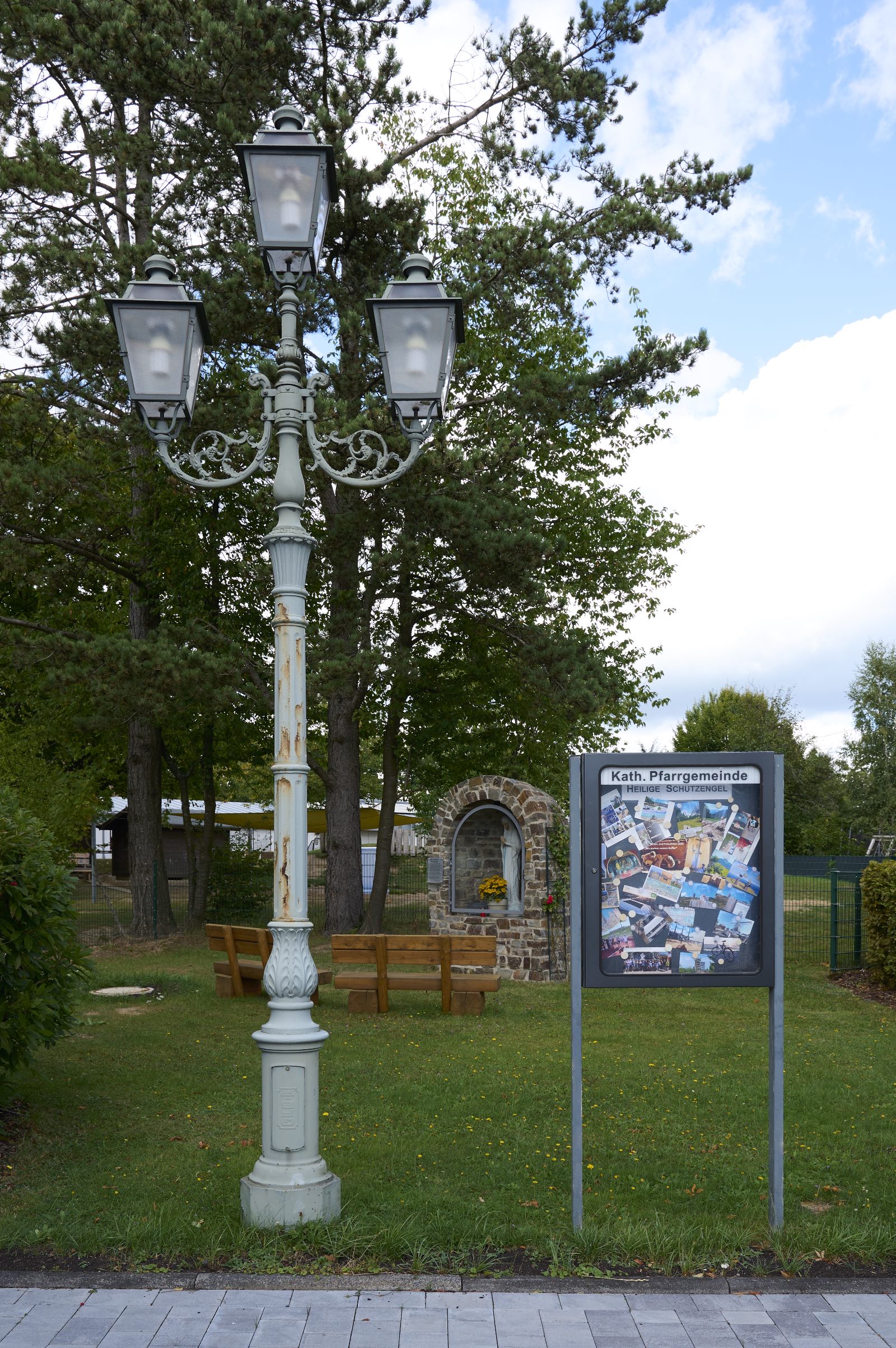Vorplatz der Kirche mit Laterne, Marienschrein und Informationsaushang